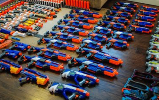 over fifty nerf blasters lined up on the floor
